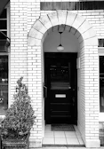 A welcoming entrance door with the Arise logo subtly displayed, framed by natural wooden accents.