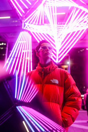 Nighttime shot of a rageraptor bomber jacket illuminated by neon city lights