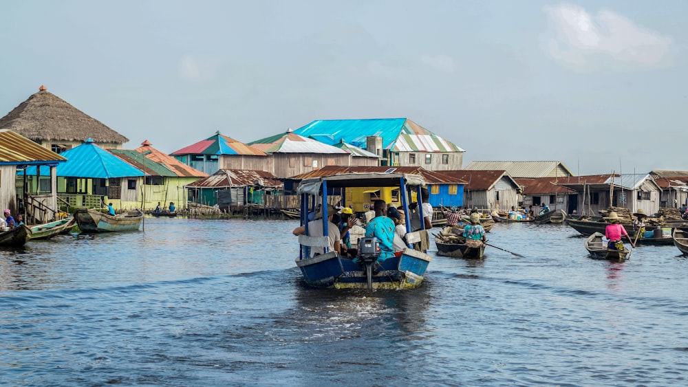 a group of people ride on boats with Tonlé Sap in the background