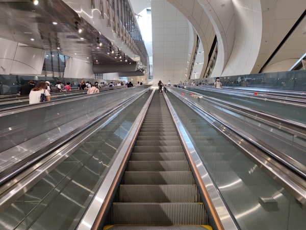 passengers on a bank of long escalators in a modern building