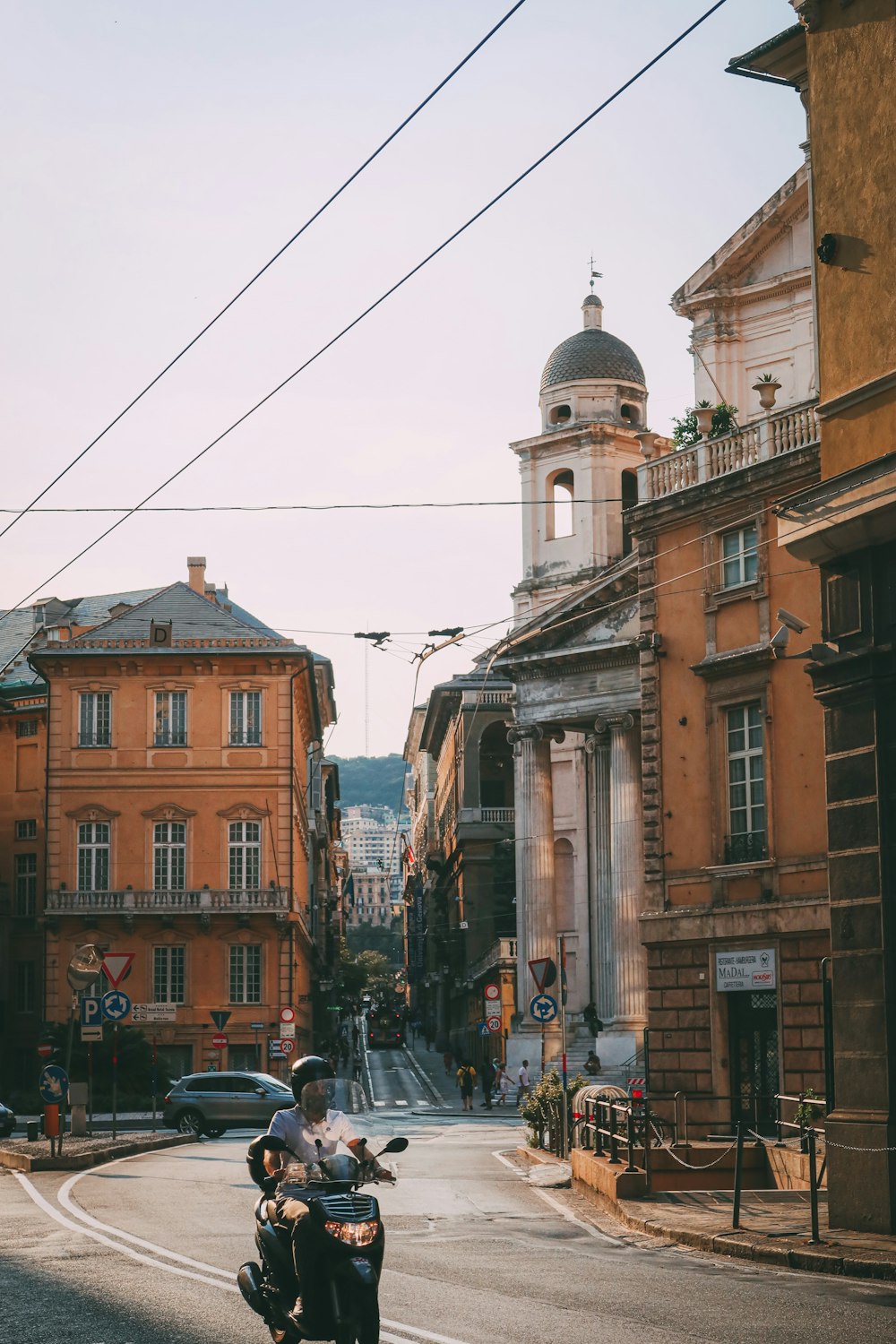 a couple of people riding a motorcycle down a street