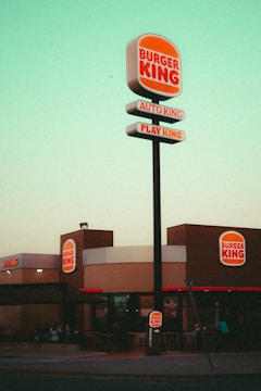 a sign with a restaurant in the background
