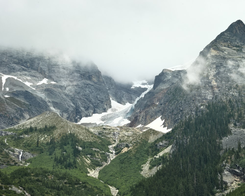 a valley between mountains with snow