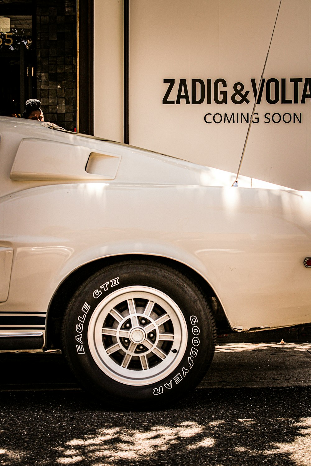 a white car parked in front of a sign