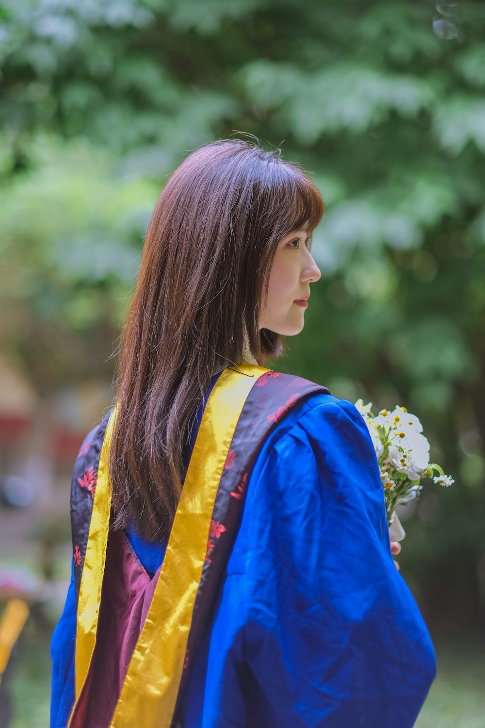 a woman in a blue and yellow dress with a flower in her hair