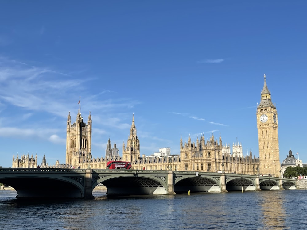 a bridge over a river with a clock tower in the background