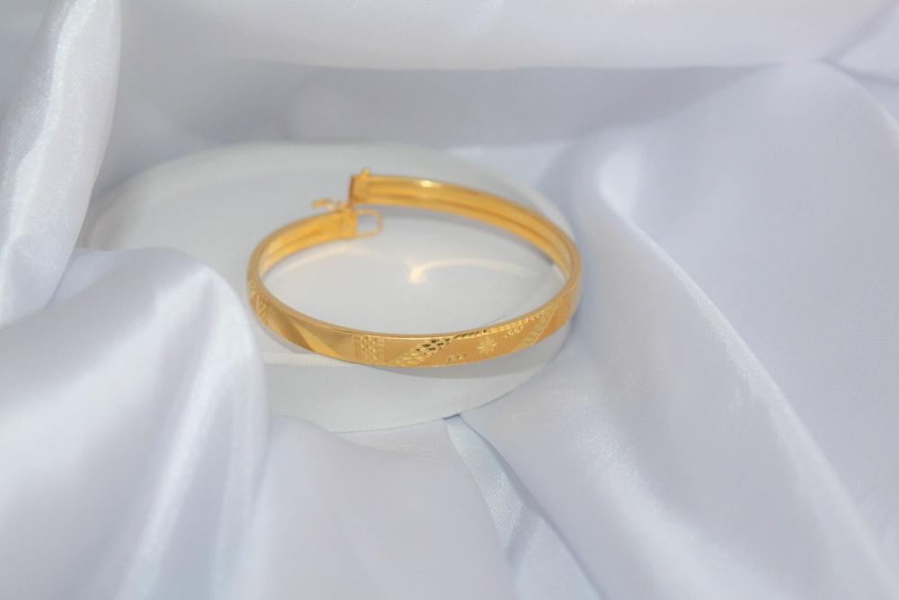 a gold ring on a white surface