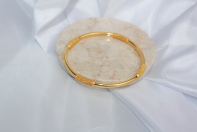 a gold ring on a white surface