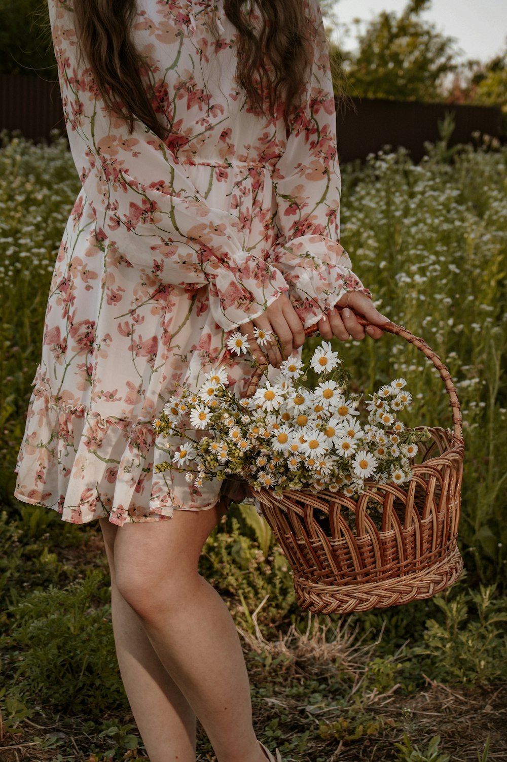 a woman holding a basket of flowers
