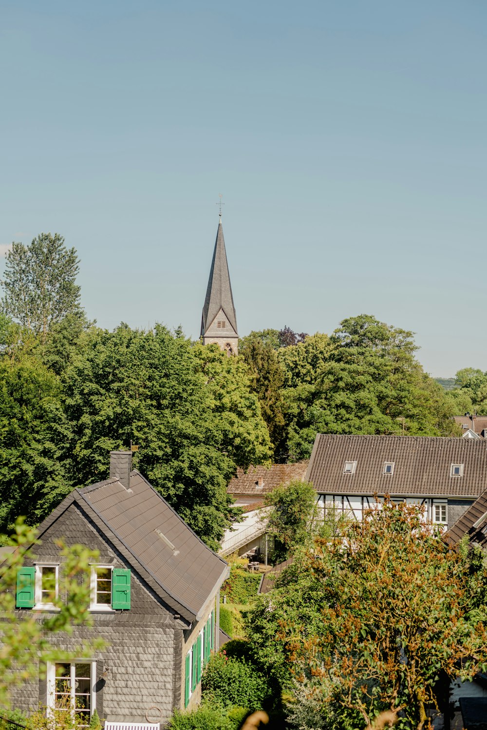 a building with a steeple behind trees