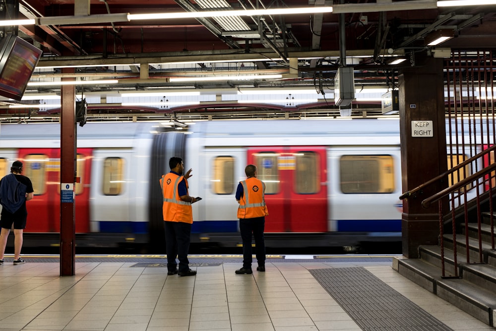 Un groupe de personnes debout devant un train