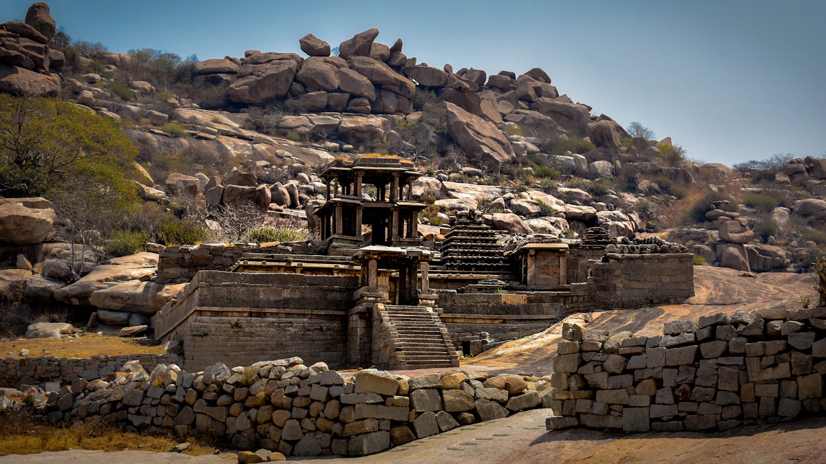 Ancient stone temple ruins and granite boulder landscape of Hampi at sunset
