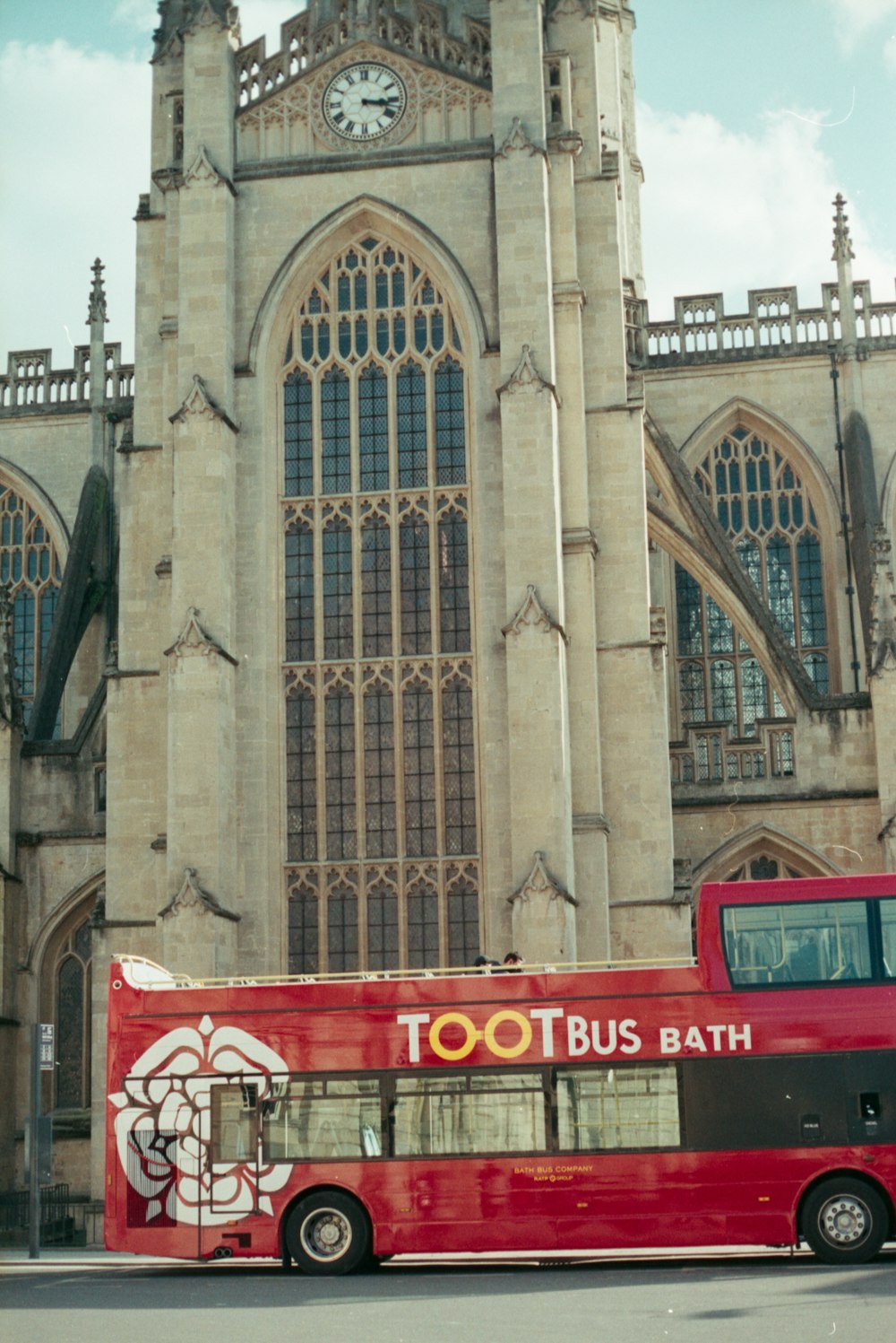 a red bus in front of a large building