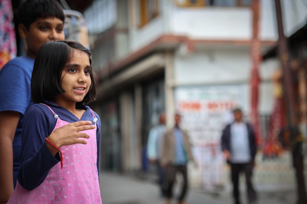 a young girl carrying a young boy