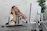 Smiling woman wearing wireless earbuds while working at a cozy home office desk.