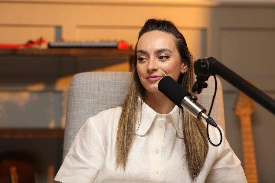 A woman speaking into a microphone in a recording studio