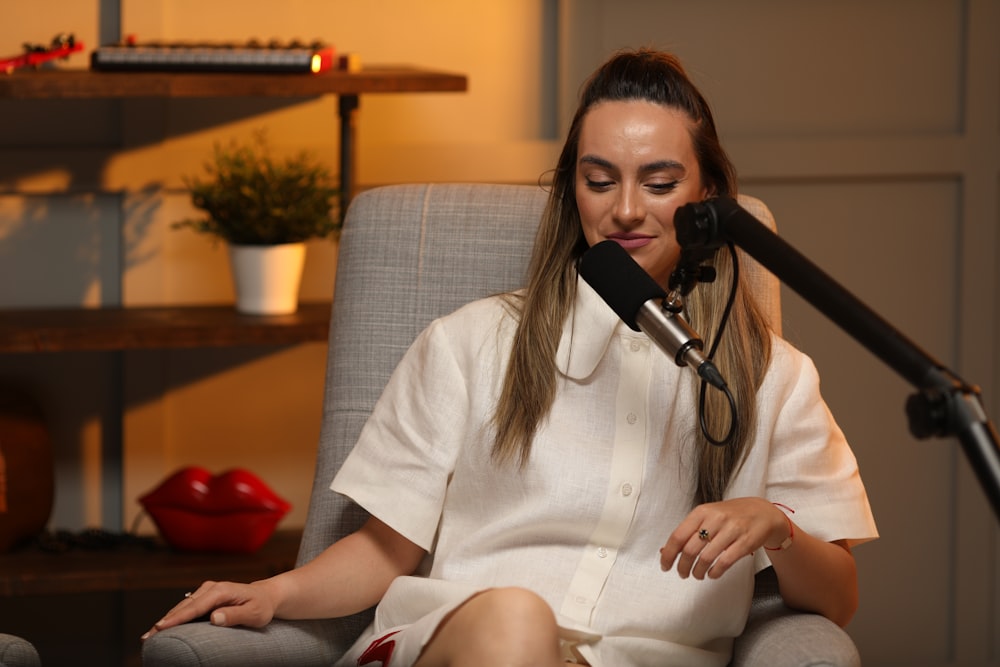 a person sitting in a chair with a microphone