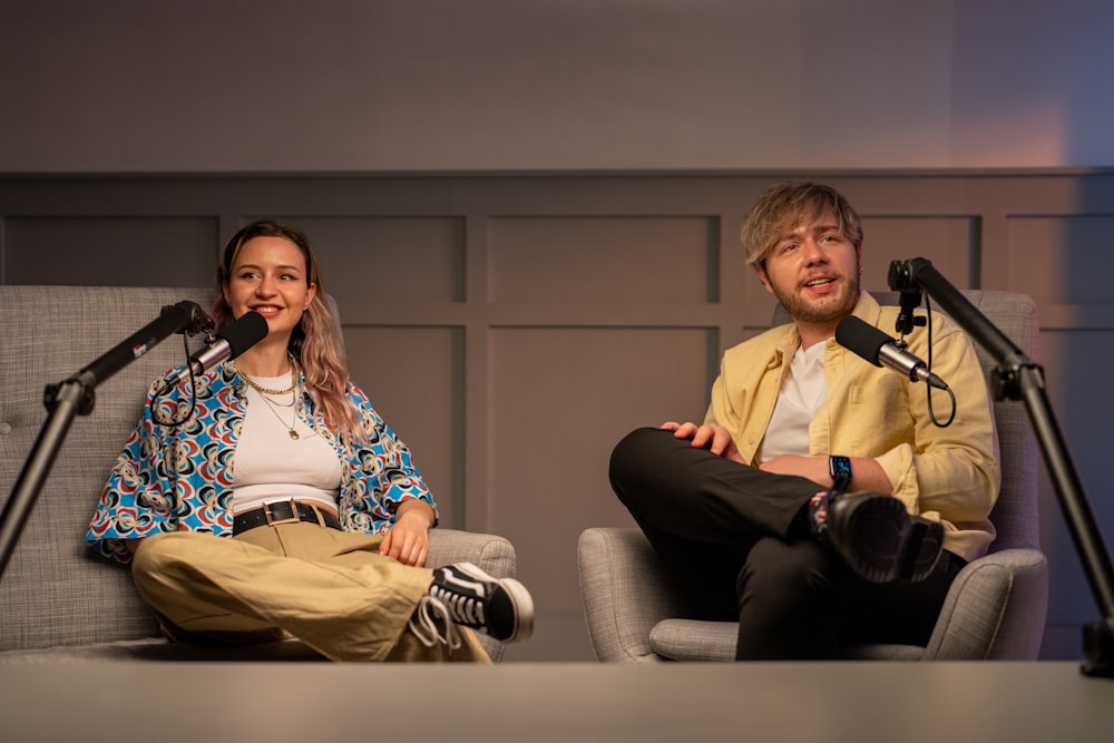 a man and a woman sitting on a stage with microphones