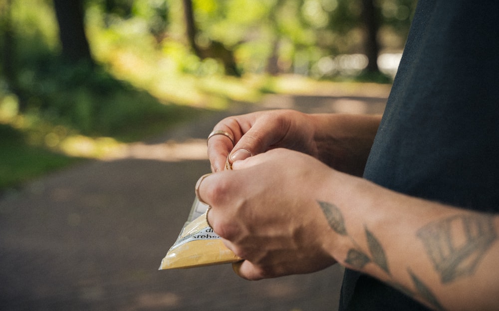 a pair of hands holding a small yellow object