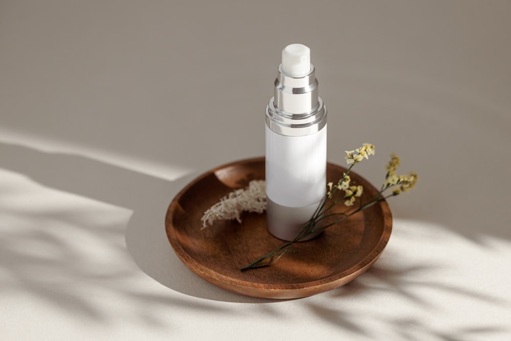 a bottle of perfume and a bowl of dried flowers