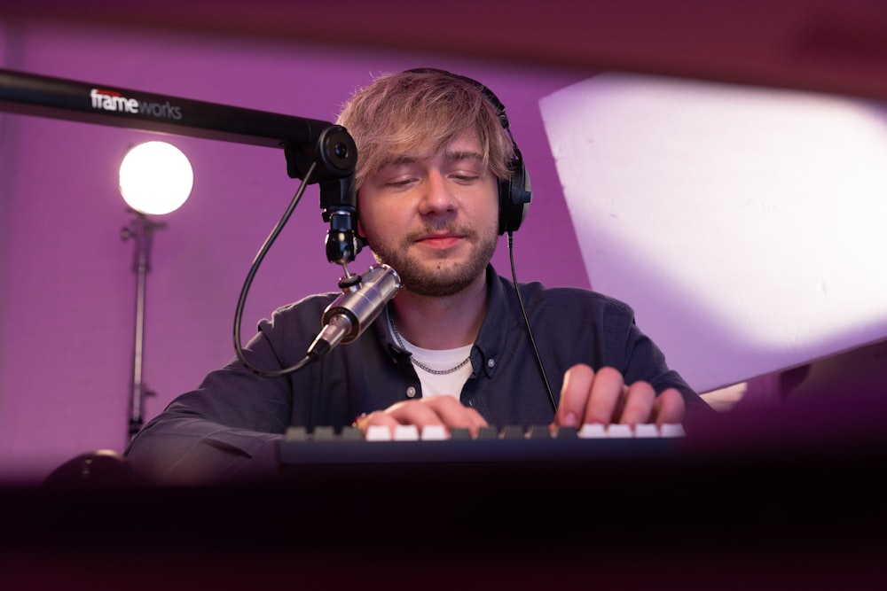 Un hombre con auriculares y tocando un teclado