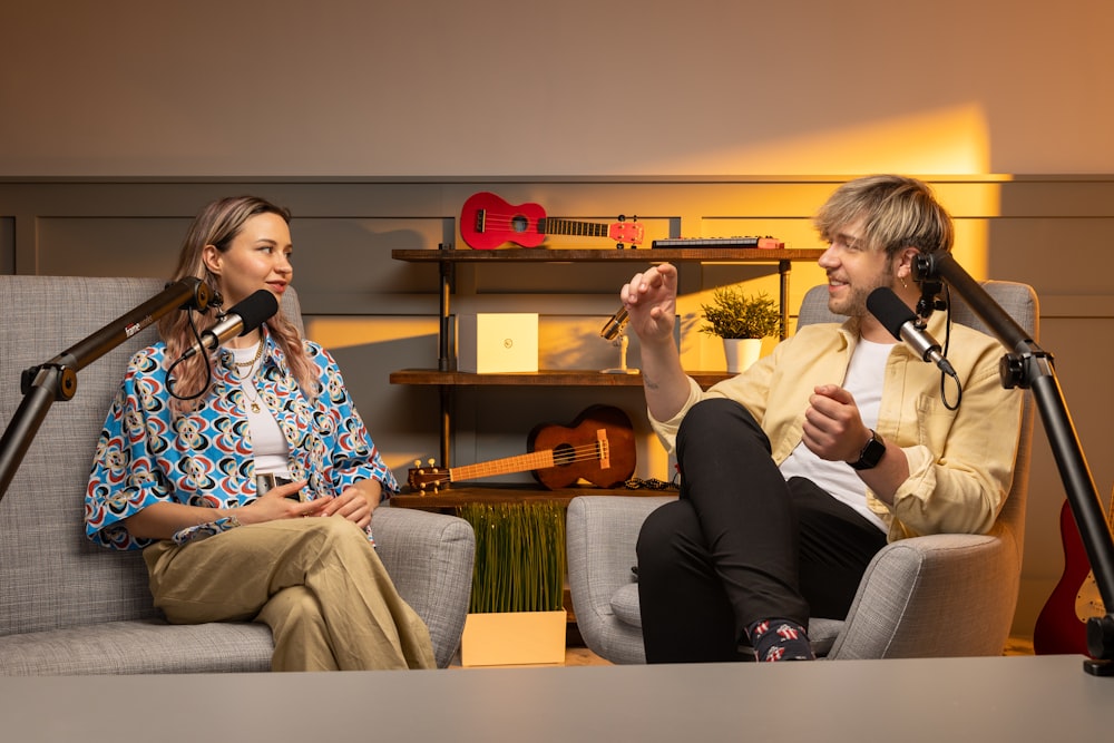 a man and a woman sitting in chairs with microphones