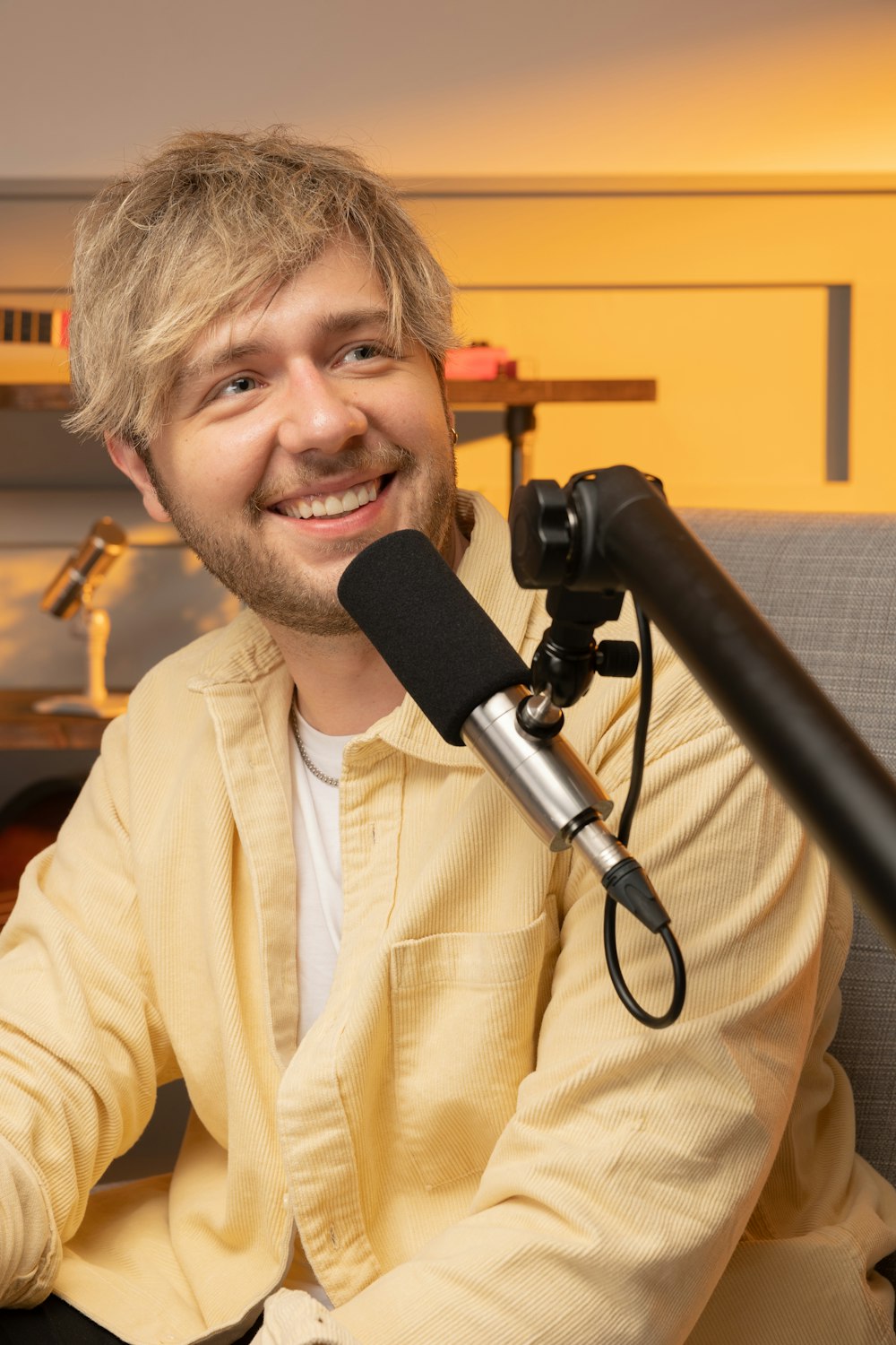 a person smiling with a microphone