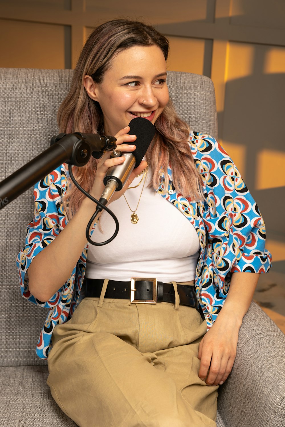 a woman sitting on a chair with a microphone in front of her