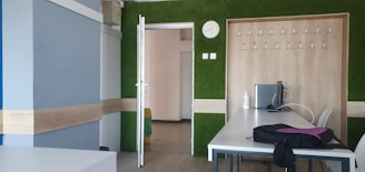 Modern office desk with computer and blue-green branding elements.