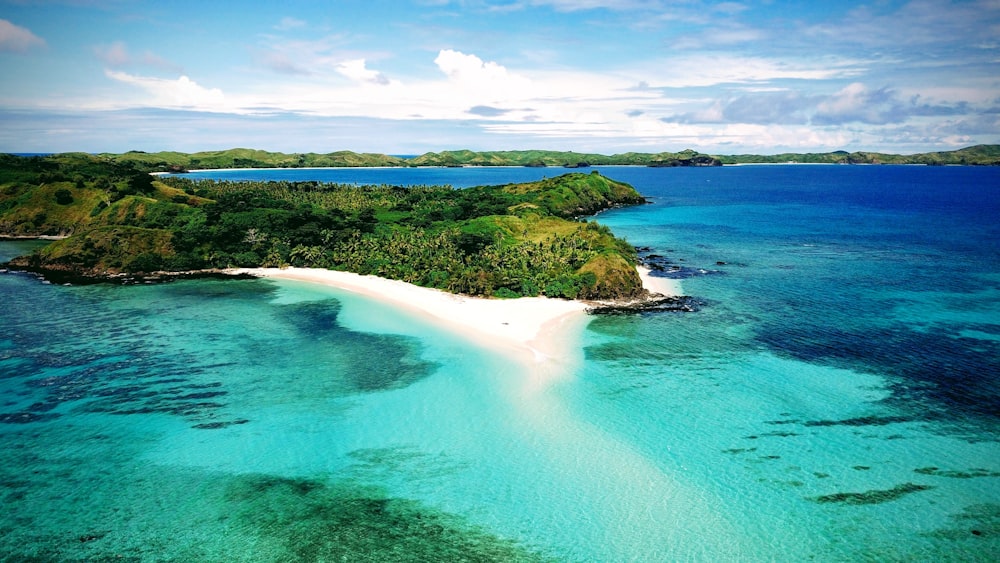 a beach with blue water and green land