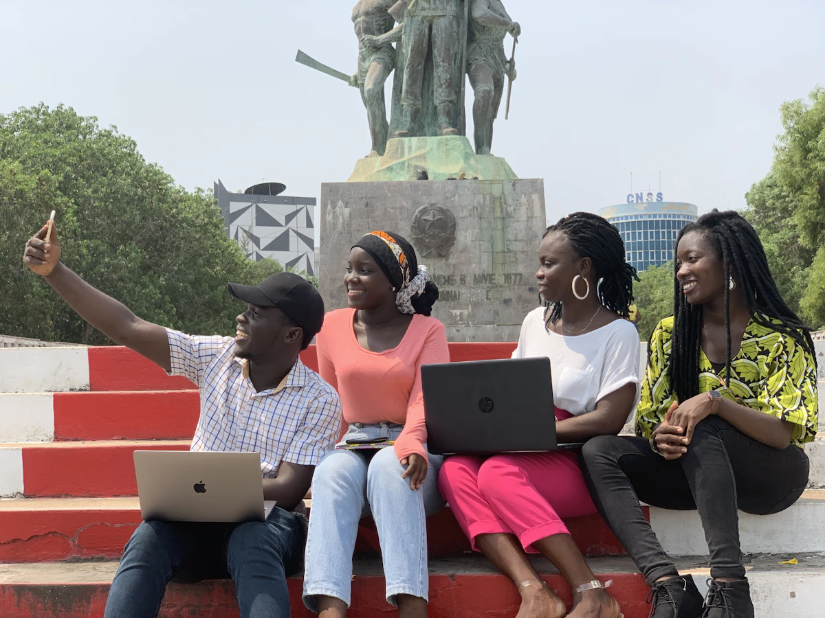 Young African learners collaborating on laptops during a digital skills training session