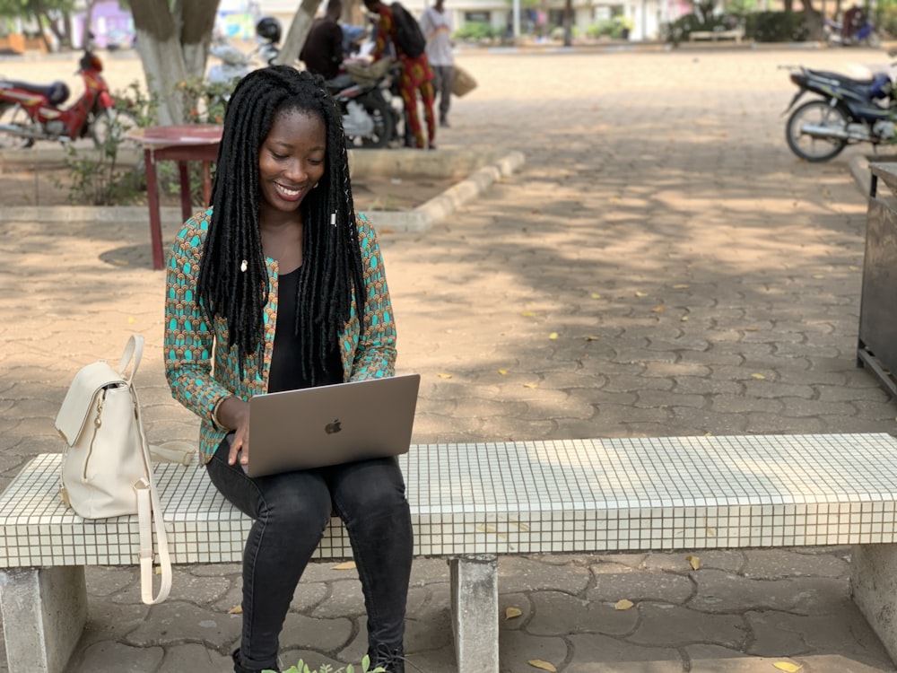 a person sitting on a bench with a laptop