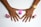 A pair of hands with freshly painted nails in a pinkish-purple color, with three bottles of nail polish placed beside them. One hand wears a gold wristwatch.