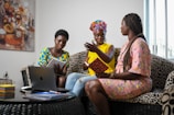 a group of people sitting on a couch looking at a laptop