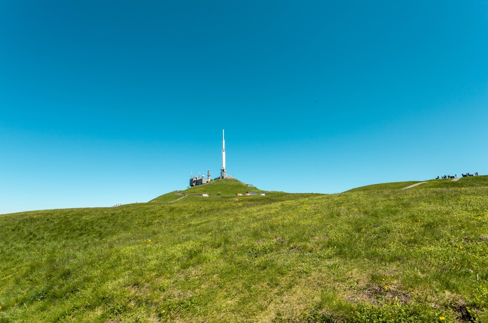 a grassy hill with a tower in the distance