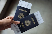 Mano sosteniendo dos pasaportes con pases de abordar.