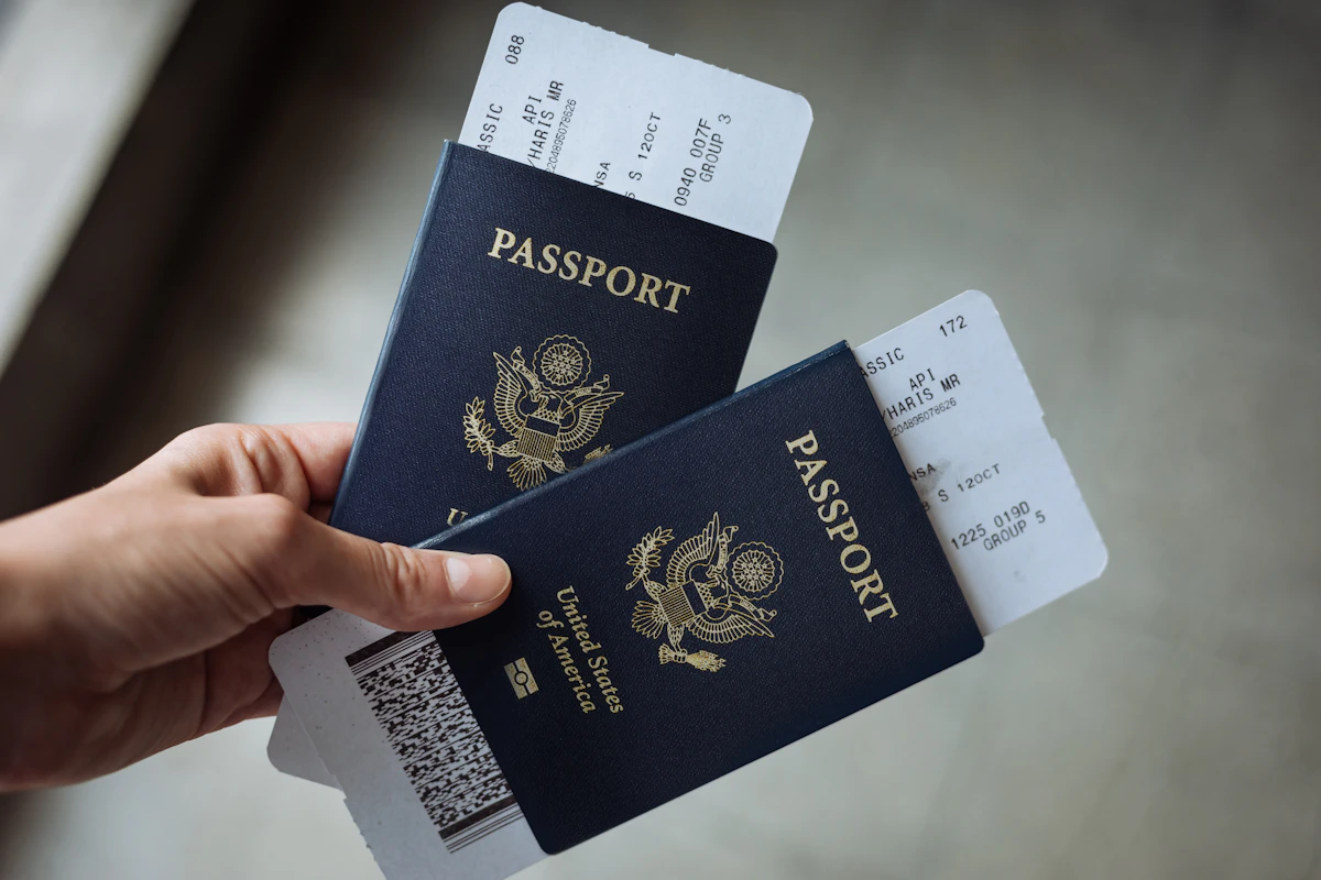 Hand holding passports with airline boarding passes tucked inside