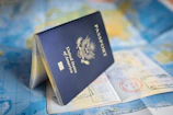 A United States passport resting open on a colorful world map