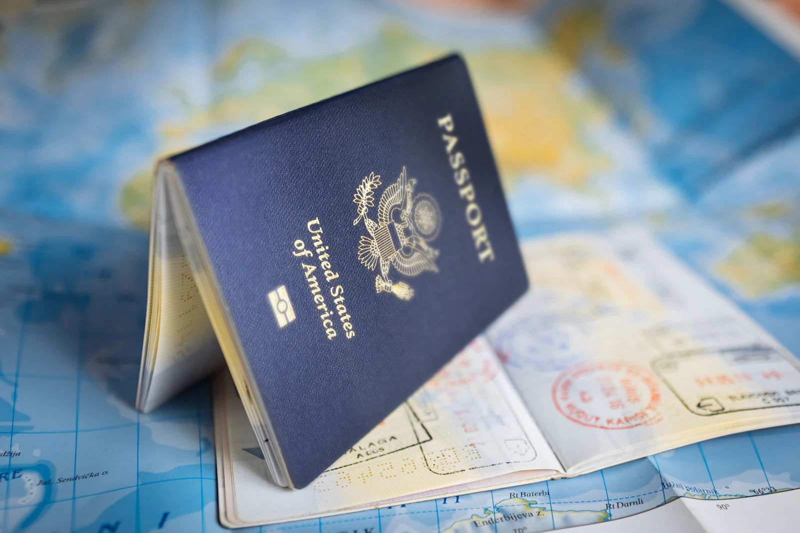 A United States passport standing open on a world map