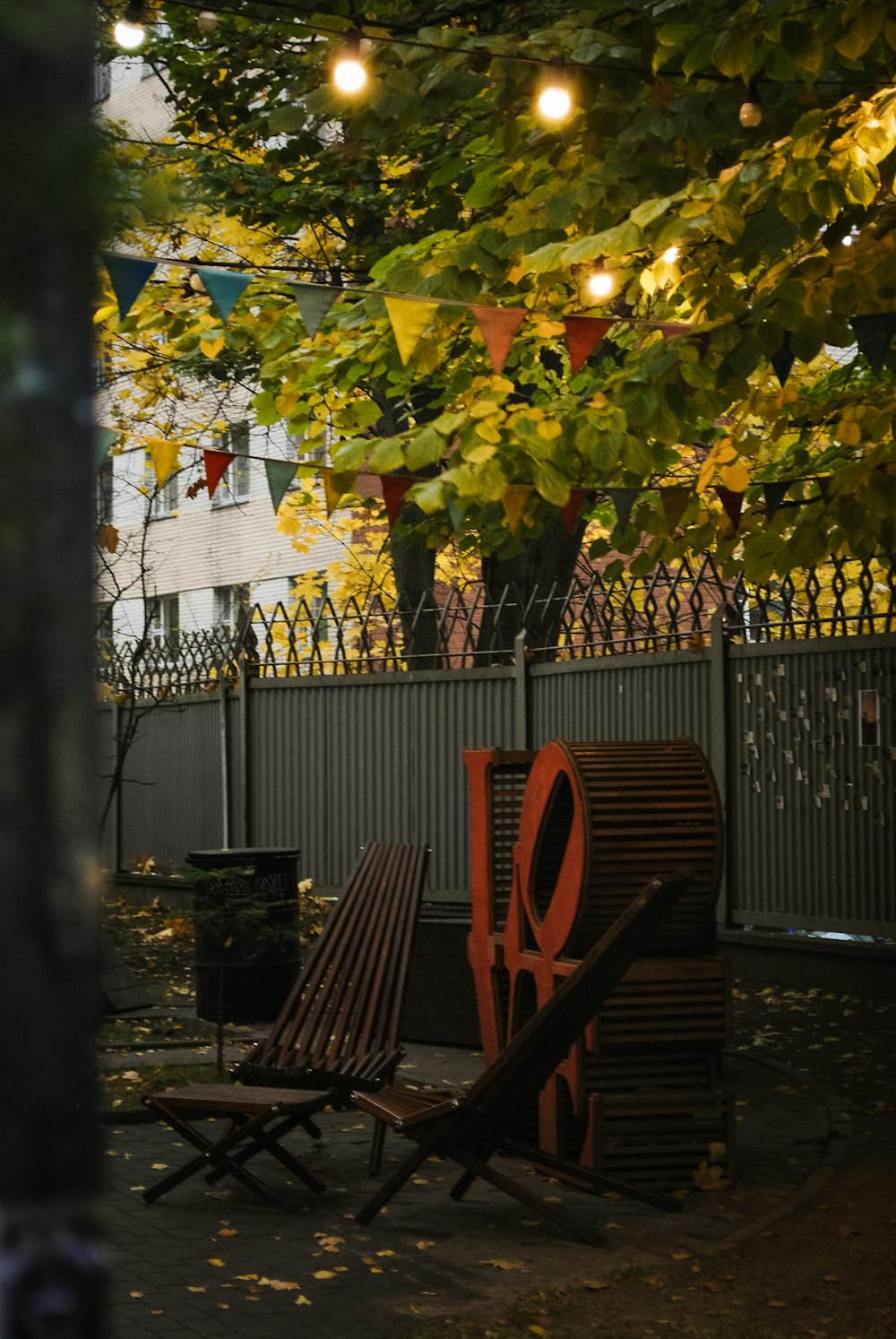 a couple of benches sit under a tree