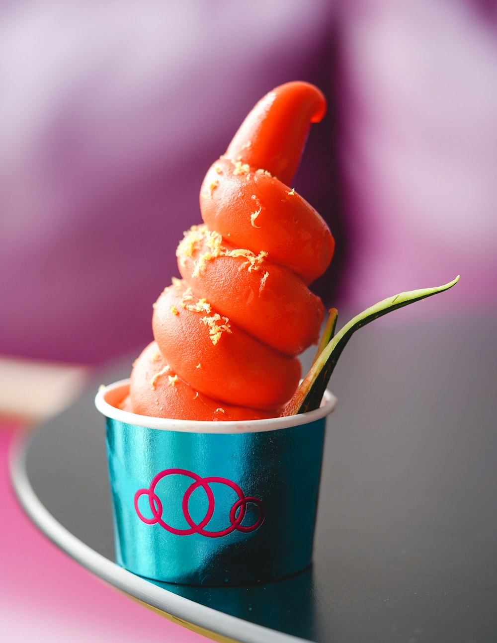 a small orange flower in a cup