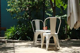 Classic mesh patio chairs paired with a small table under soft shade.