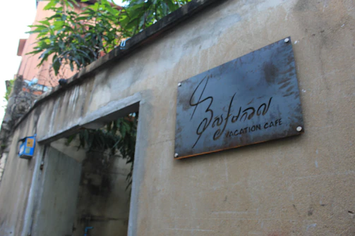 A stylish metal sign featuring a black and white cityscape hanging on a rustic wall.