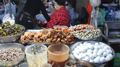 A vibrant market scene in Lagos with baskets of snails ready for processing.