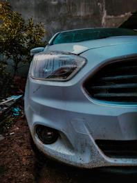 Close-up of a dusty, muddy car exterior before cleaning.