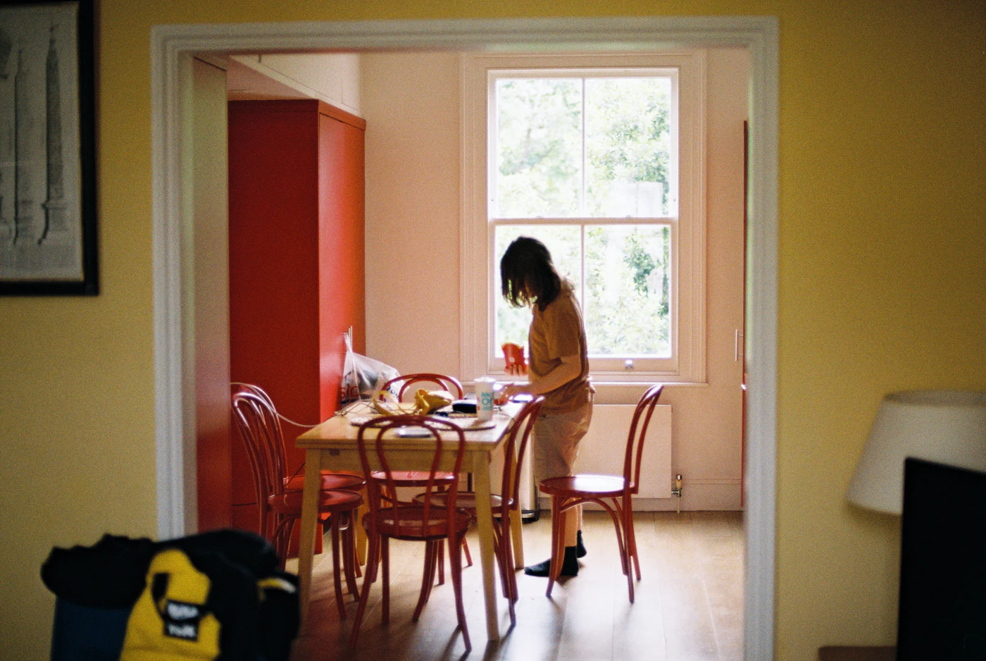 A woman setting a small table in a bright kitchen