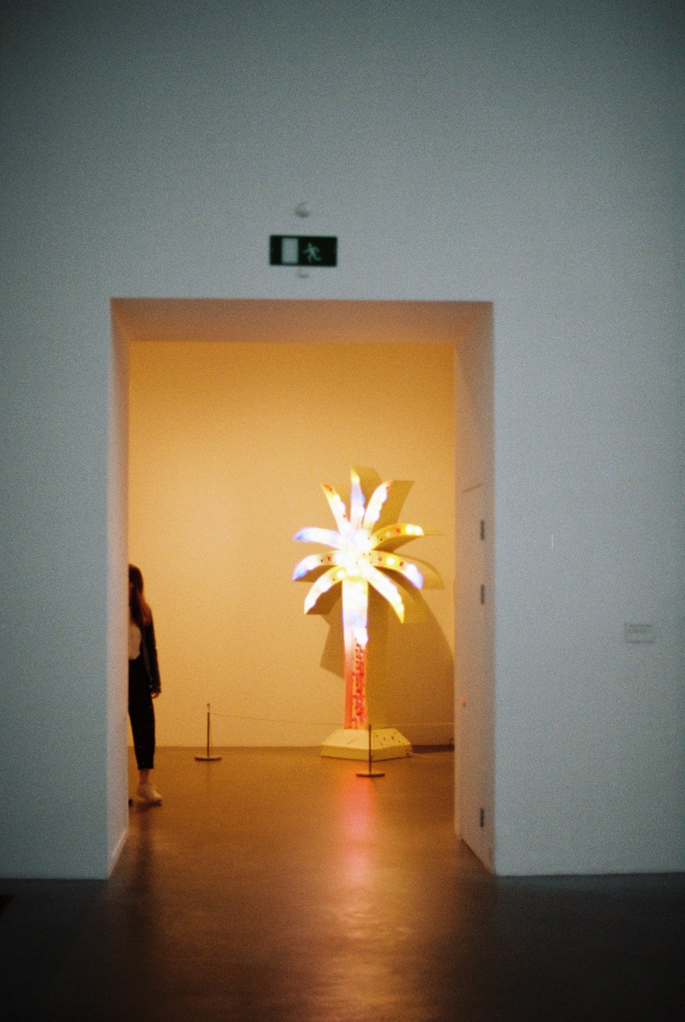 a person standing in a room with a large light in the middle