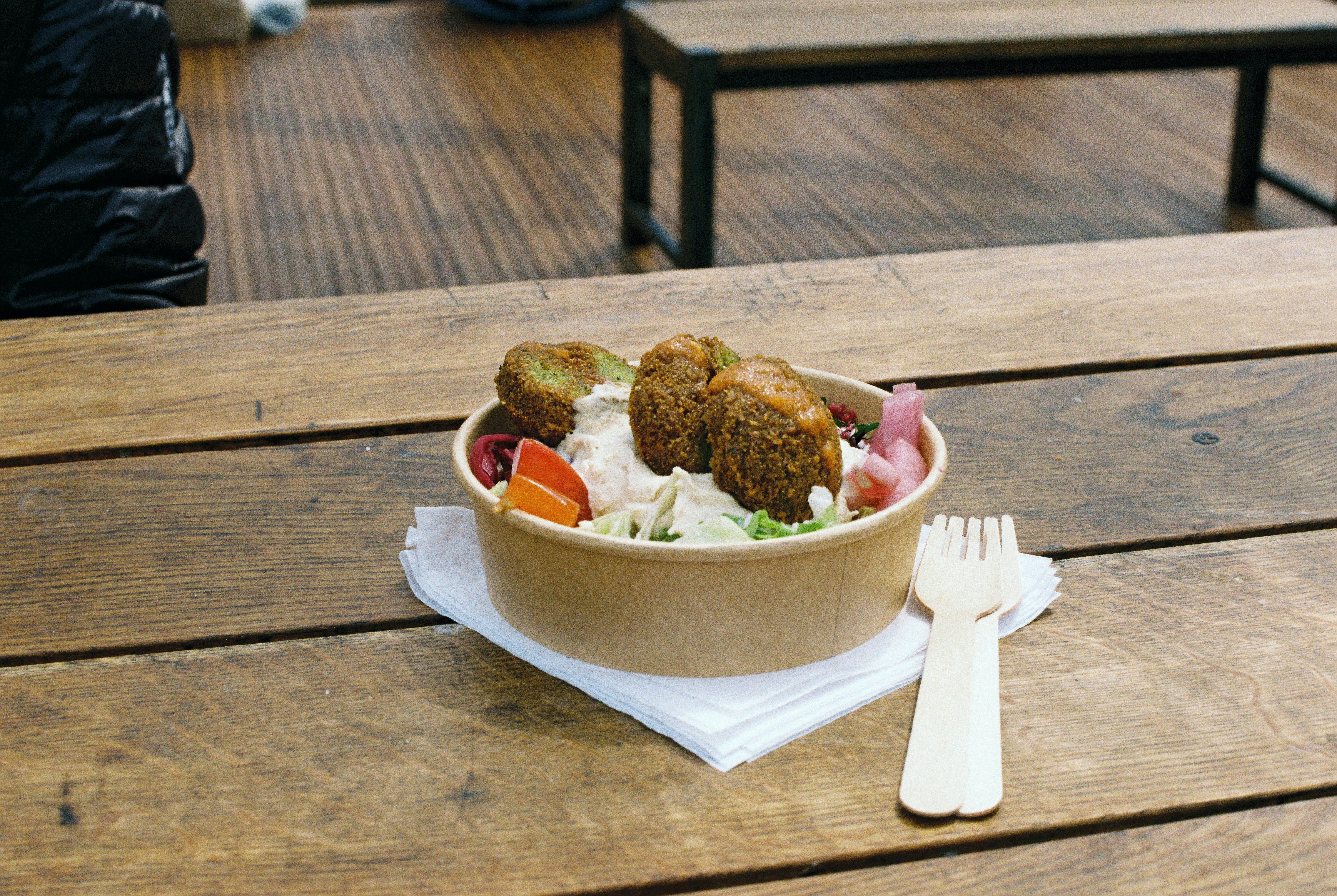 Falafel bowl on an outdoor timber table