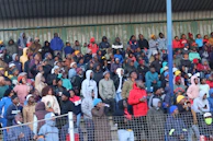 Audience members leaning forward, eyes wide, caught in the suspense of the game.