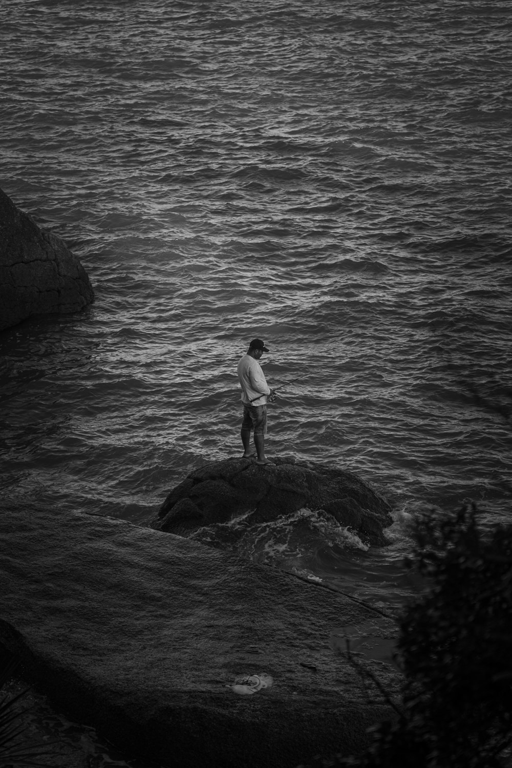 Un hombre parado sobre una roca en el agua